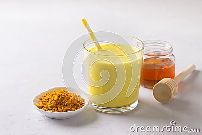 Golden milk with turmeric in a glass with honey on a gray stone Stock Photo