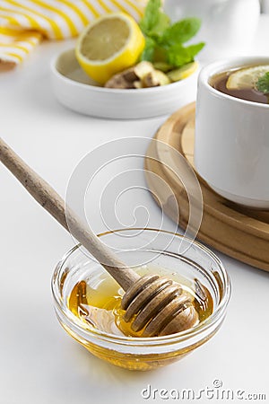 Golden natural honey autumn winter hot drink ingredient glass bowl honey spoon seasonal Stock Photo