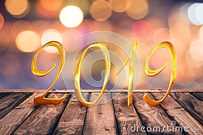 2019, golden numbers on wood table with blurred lights gold bokeh background Stock Photo