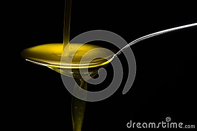 Golden olive oil over metal spoon Stock Photo