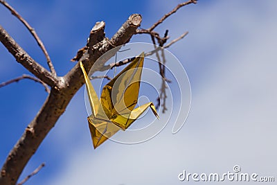 Golden Origami Crane Hanging From a Cherry Blossom Tree Stock Photo