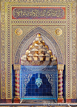 Golden ornate arched mihrab niche with floral pattern, blue Turkish ceramic tiles and arabic calligraphy, Cairo, Egypt Stock Photo