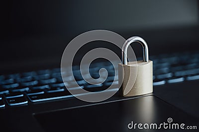 A golden padlock placed on laptop computer keyboard Stock Photo