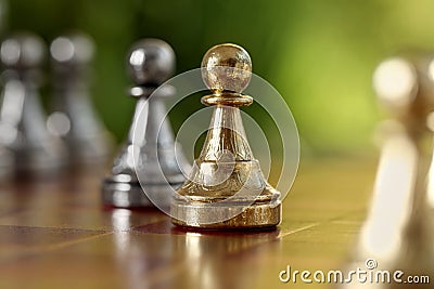 Golden pawn on chess board against blurred background, closeup Stock Photo