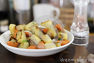 Golden Potatoes Are Fried With Carrot And Onion On A Plate Stock Photo