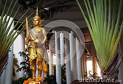 Golden Rama statue wearing traditional costume. Gold Hindu god sculpture holding sword and cloth sack Editorial Stock Photo