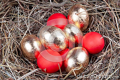 Golden and red eggs in a nest top view. Concept easter Stock Photo