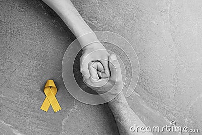 Golden ribbon childhood symbol in male hands Stock Photo