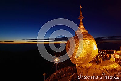 Golden Rock at twilight with praying people, KyaiKhtiyo pagoda, Stock Photo