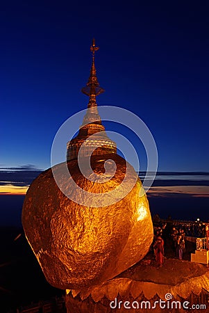 Golden Rock at twilight with praying people, KyaiKhtiyo pagoda, Stock Photo