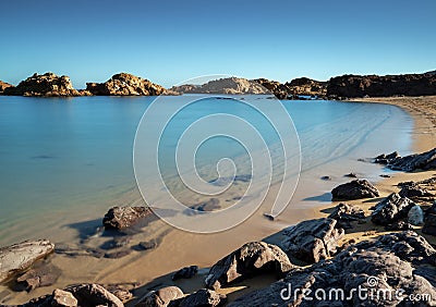 golden sand beach and turquoise waters at the idyllic Cala Pregonda in northern Menorca Stock Photo