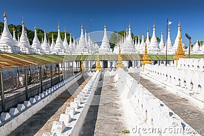 Golden Sandamuni Pagoda with row of white pagodas. Amazing architecture of Buddhist Temples at Mandalay, Myanmar Stock Photo