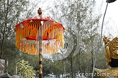 A golden sculpture taken from back and traditional umbrella often used as a decoration or cultural ceremony Editorial Stock Photo