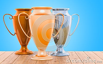 Golden, silver and bronze trophy cups on the wooden table, 3D re Stock Photo