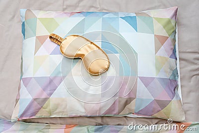 Golden sleeping eye mask on the bed, top view. Good night, flight and travel concept. Sweet dreams, siesta, insomnia, relaxation, Stock Photo