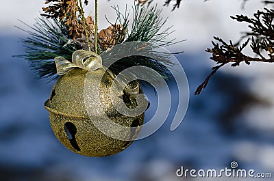 Golden Sleigh Bell Christmas Ornament Decorating an Outdoor Tree Stock Photo