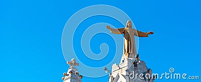 Golden Statue of Jesus Christ on the facade of the Temple of the Sacred Heart of Jesus, Barcelona, Catalonia, Spain. Isolated on Editorial Stock Photo