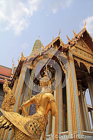 Golden statue of a Kinnara guarding Wat Phra Kaew Stock Photo