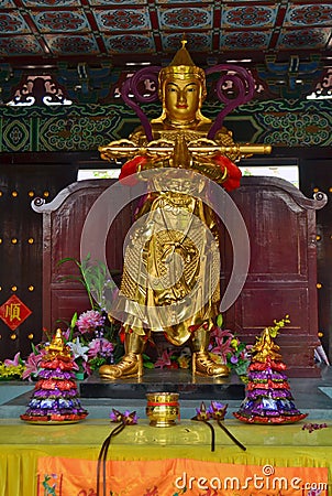 Golden Statue and offerings in Traditional Chinese Buddhist temple in Lumbini, Nepal Stock Photo