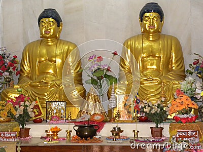 Sarnath, Uttar Pradesh, India - November 1, 2009 Golden statues of sitting Buddha at Maha Bodhi Society Buddhist temple Editorial Stock Photo