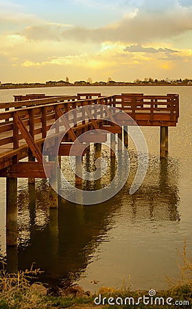 Golden Sun Sets on Lake and Pier Stock Photo