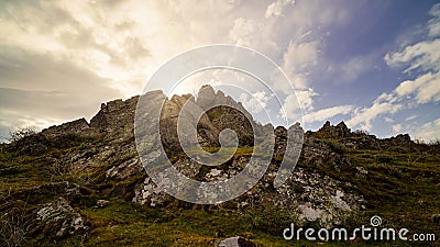 Golden sunrise on the mountain with sun rays coming out from behind the rocks and idyllic atmosphere. La Hiruela Madrid Stock Photo