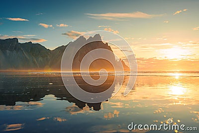 Golden sunrise over Vestrahorn mountain reflection on the beach in Stokksnes peninsula at Iceland Stock Photo