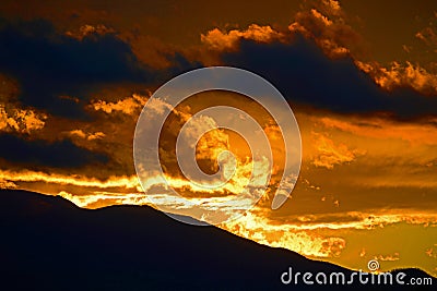 Golden Sunrise Sunset with Silhouetted Moutnains Stock Photo