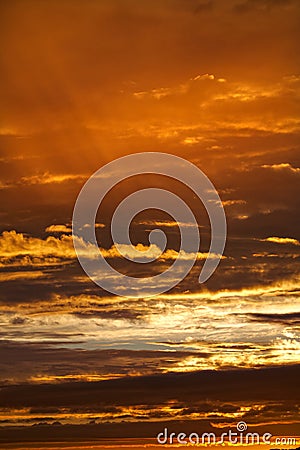 Golden sunset with clouds in the sky with light rays color photo. Stock Photo