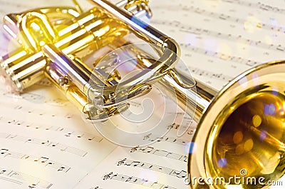 Golden trumpet on sheet music with scenic reflections and lens flare Stock Photo