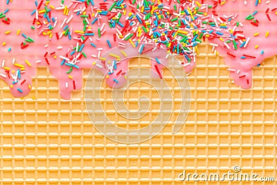 Golden waffle texture with pink icing and sprinkles, background for your design Stock Photo