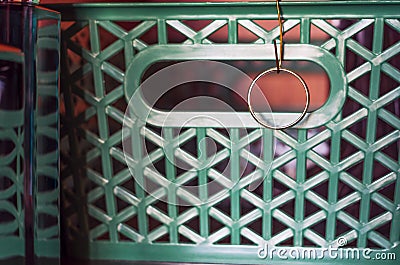 Golden Wedding Ring Hanging on a Wire Hook Attached to the Green Wardrobe Shelf Organizer Basket, With Reflections in Perfume Stock Photo