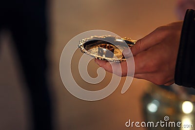 golden wedding rings on plate in priest hand at traditional ceremony in church Stock Photo