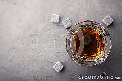 Golden whiskey in glass with cooling stones on table, top view. Stock Photo