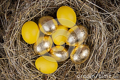 Golden and yellow eggs in a nest top view. Concept easter Stock Photo