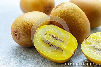 Golden yellow organic kiwi. Whole and cut ripe juicy fruits on grey background. kiwifruit Stock Photo