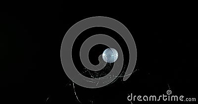 Golf Ball breaking Pane of Glass against Black Background Stock Photo