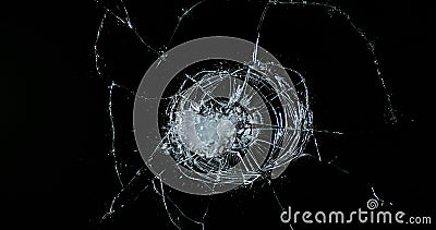 Golf Ball breaking Pane of Glass against Black Background Stock Photo