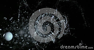 Golf Ball breaking Pane of Glass against Black Background Stock Photo