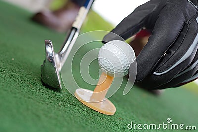 Golf ball hand gloves on yellow tee Stock Photo
