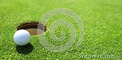 Golf ball on lip of cup Stock Photo