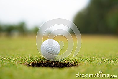 Golf ball on lip of cup close up, Golf ball on the lawn Stock Photo