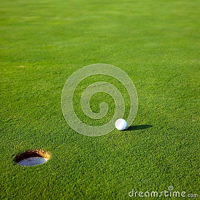 Golf ball near hole Stock Photo