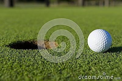 Golf Ball Near Hole Stock Photo