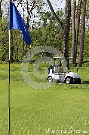 Golf cart and hole pin on the course Editorial Stock Photo