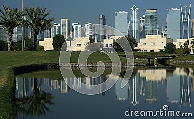 A golf course in Dubai with palm trees and skyscrapers in the background Stock Photo