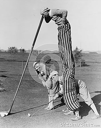 Golf game with man on stilts Stock Photo
