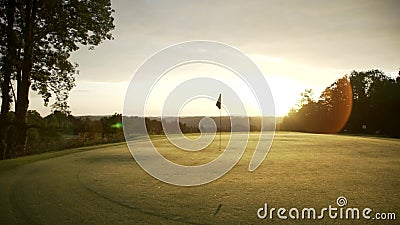 Golf Groen bij ochtendzonsopgang De vlag bevindt zich op green terwijl de zon in de rug toeneemt Geen mensen daar stock video Golf Groen bij ochtendzonsopgang De vlag bevindt zich op green terwijl de zon in de rug toeneemt Geen mensen daar stock video