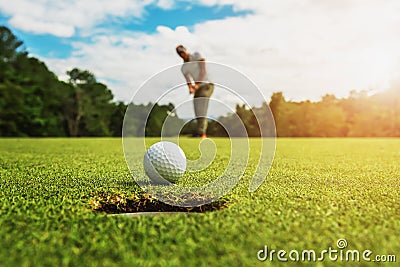 golf player putting golf ball into hole Stock Photo