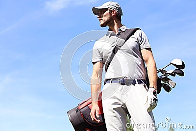 Golf player walking and carrying bag on course during summer game golfing Stock Photo